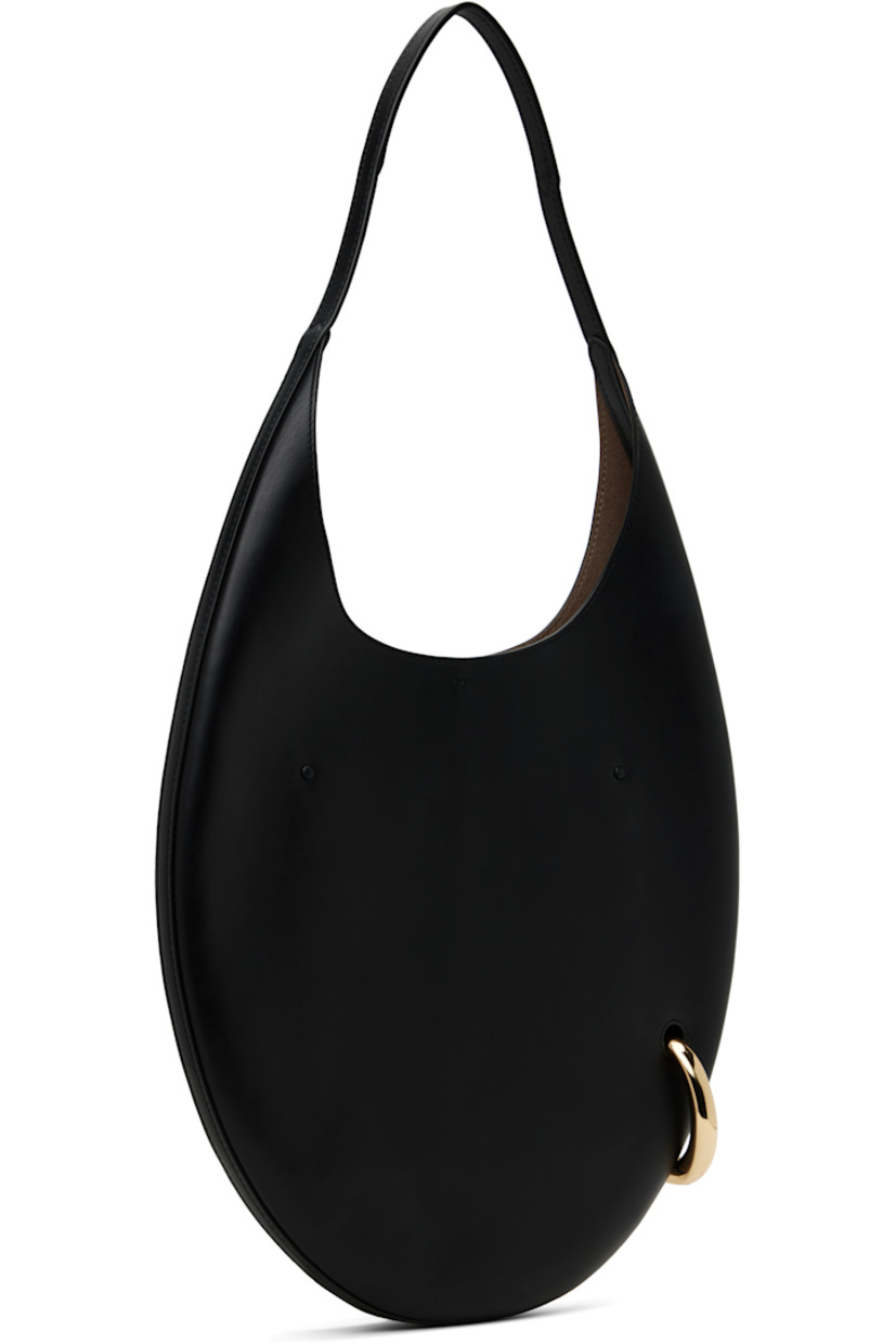 Buffed leather shoulder bag in black.

· Fixed shoulder strap
· Gold-tone O-ring at side
· Self-tie closure
· Zip pocket at interior
· Faux-suede lining
· H12" x W12.5" x D1"
· Total height: H23"
 
Supplier color: Black/Gold