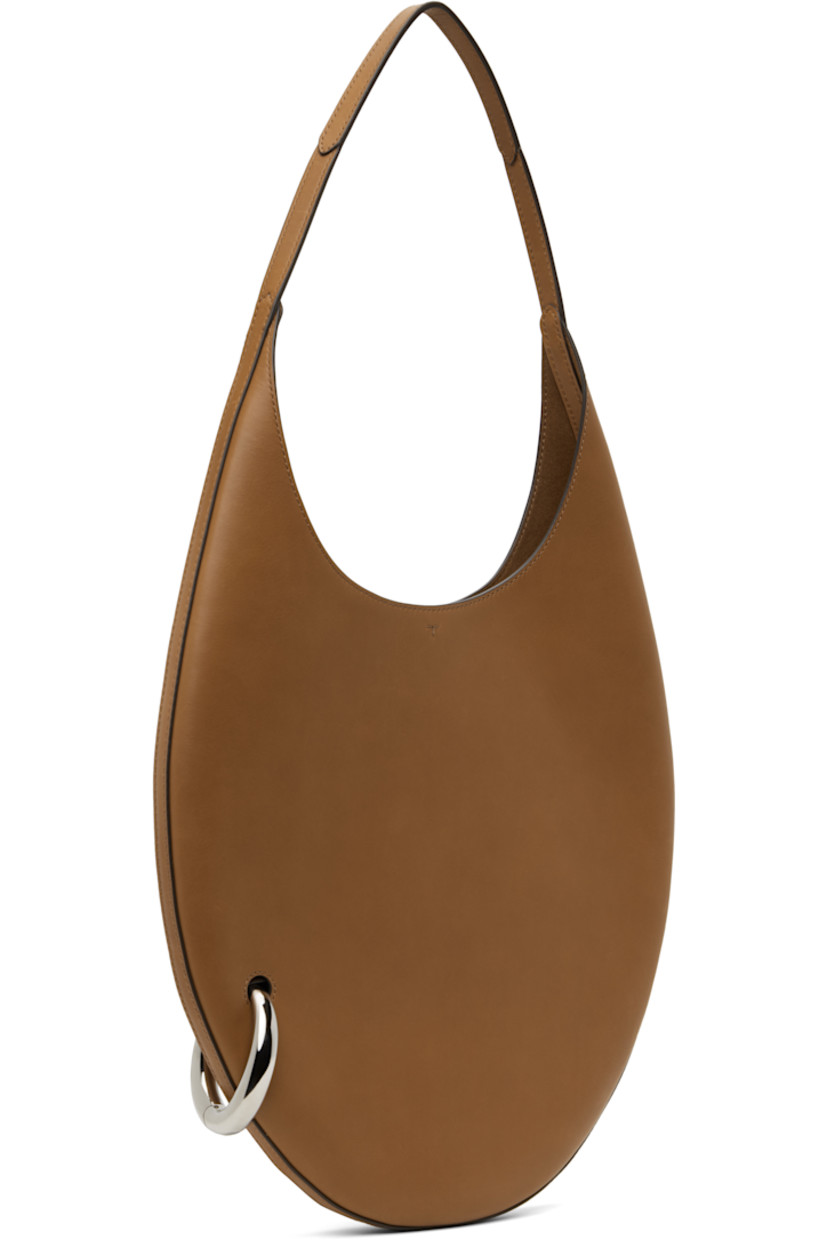Buffed leather shoulder bag in tan.

· Fixed shoulder strap
· Silver-tone O-ring at side
· Self-tie closure
· Zip pocket at interior
· Faux-suede lining
· H12" x W12.5" x D1"
· Total height: H23"
 
Supplier color: Aged tan
