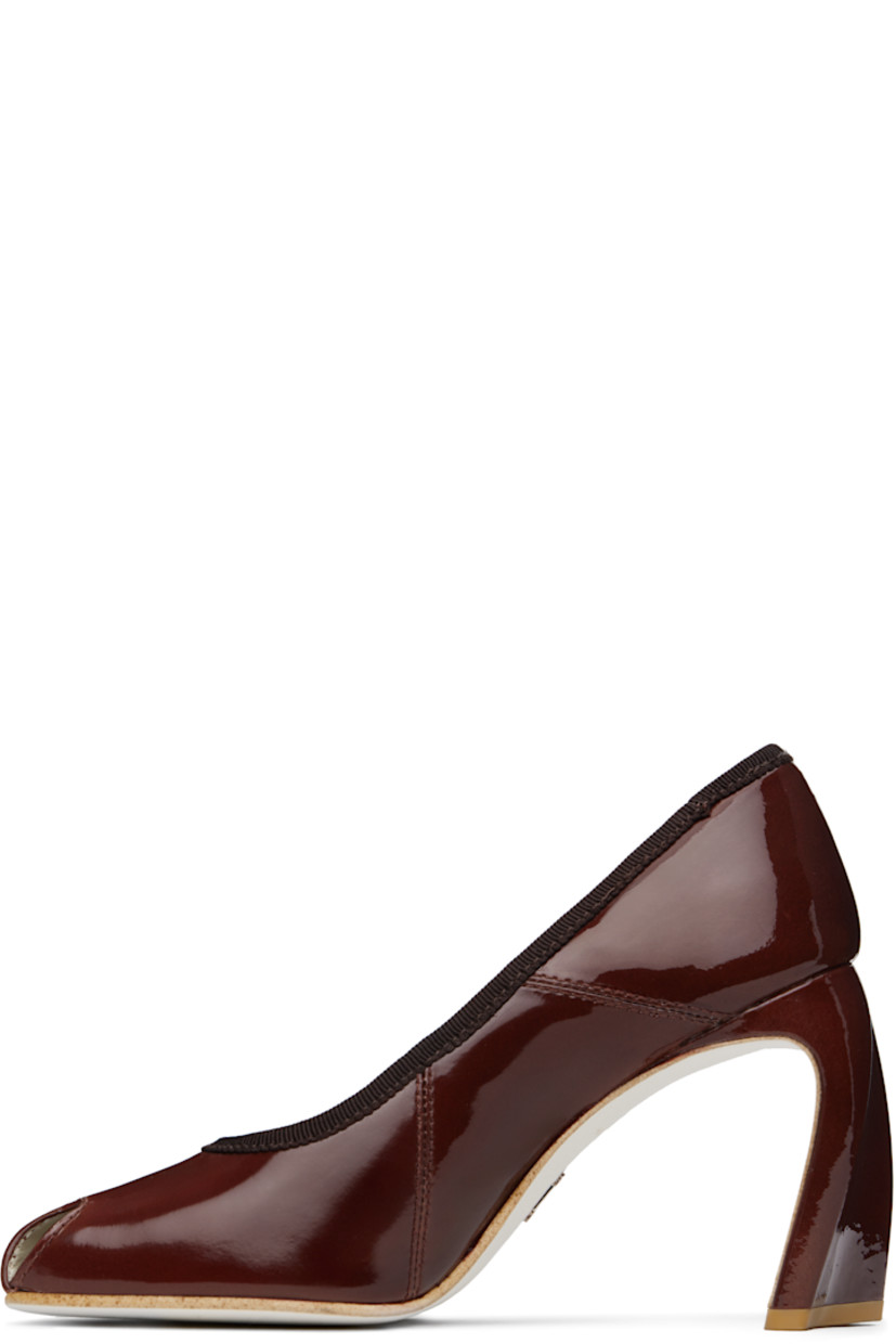 Patent leather heels in brown.

· Cutout at modified almond toe
· Grosgrain trim at collar
· Buffed leather lining
· Covered heel with rubber injection
· Leather sole
· Heel: H3.5"

Supplier color: Russet brown