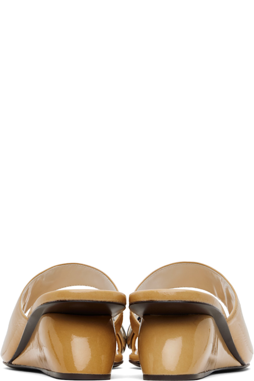 Patent goatskin mules in beige.

· Cutout at vamp
· Silver-tone hardware at toe strap
· Logo stamp at padded footbed
· Covered wedge heel with rubber injection
· Polished leather sole
· Heel: H2"

Supplier color: Cantucci/Silver