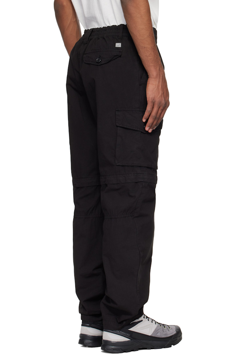 Garment-dyed cotton canvas cargo pants.

· Loose-fit
· Belt loops at partially elasticized waistband
· Three-pocket styling
· Zip fly
· Pleats at front
· Concealed bungee-style drawstring at knees
· Detachable zip panel at knees for shorts styling
· Flap pockets at outseam
· Cargo pocket at outseam
· Logo patch at back

Supplier color: Black