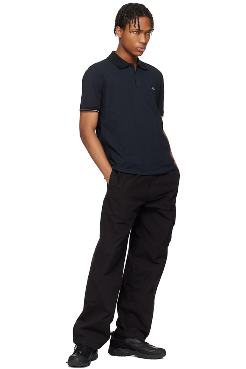 Garment-dyed cotton- and nylon-blend piqué polo.

· Rib-knit spread collar and cuffs
· Two-button placket
· Embroidered logo patch at chest
· Tennis-tail hem
· Stripe at cuffs

Supplier color: Black