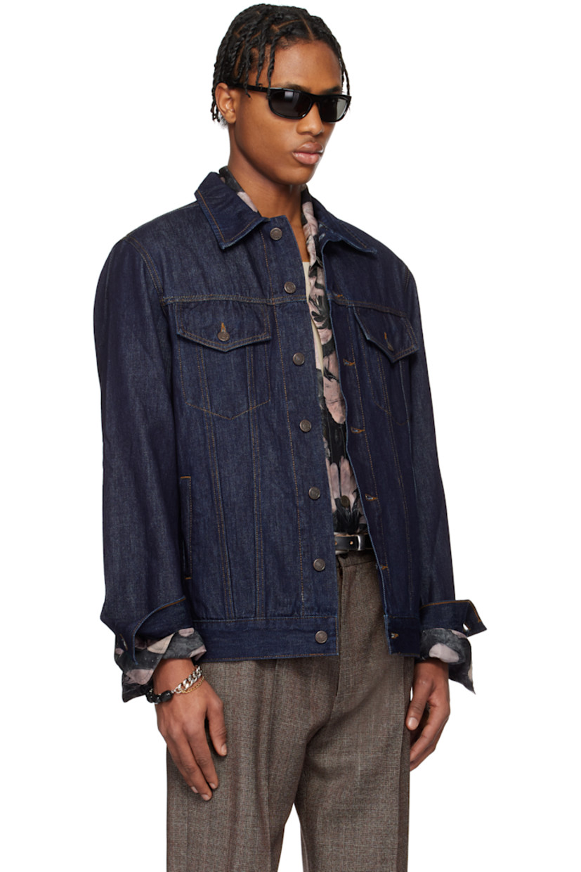 Paneled non-stretch denim jacket.

· Spread collar
· Button closure
· Flap and welt pockets
· Adjustable single-button barrel cuffs
· Logo-engraved bronze-tone hardware
· Contrast stitching in tan

Supplier color: Indigo