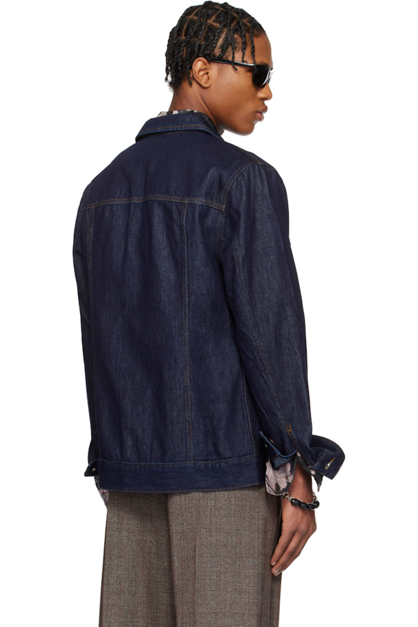 Paneled non-stretch denim jacket.

· Spread collar
· Button closure
· Flap and welt pockets
· Adjustable single-button barrel cuffs
· Logo-engraved bronze-tone hardware
· Contrast stitching in tan

Supplier color: Indigo