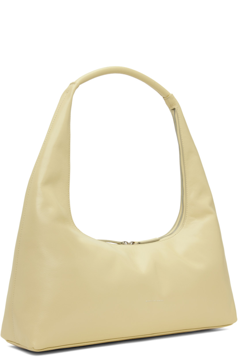 Buffed leather shoulder bag in beige.

· Fixed shoulder strap
· Logo stamp at face
· Two-way zip closure
· Patch pocket at interior
· Logo-patterned moiré lining
· Logo-engraved antiqued silver-tone hardware
· H7" x W16" x D3.5"

Supplier color: Blond wood glossy plain