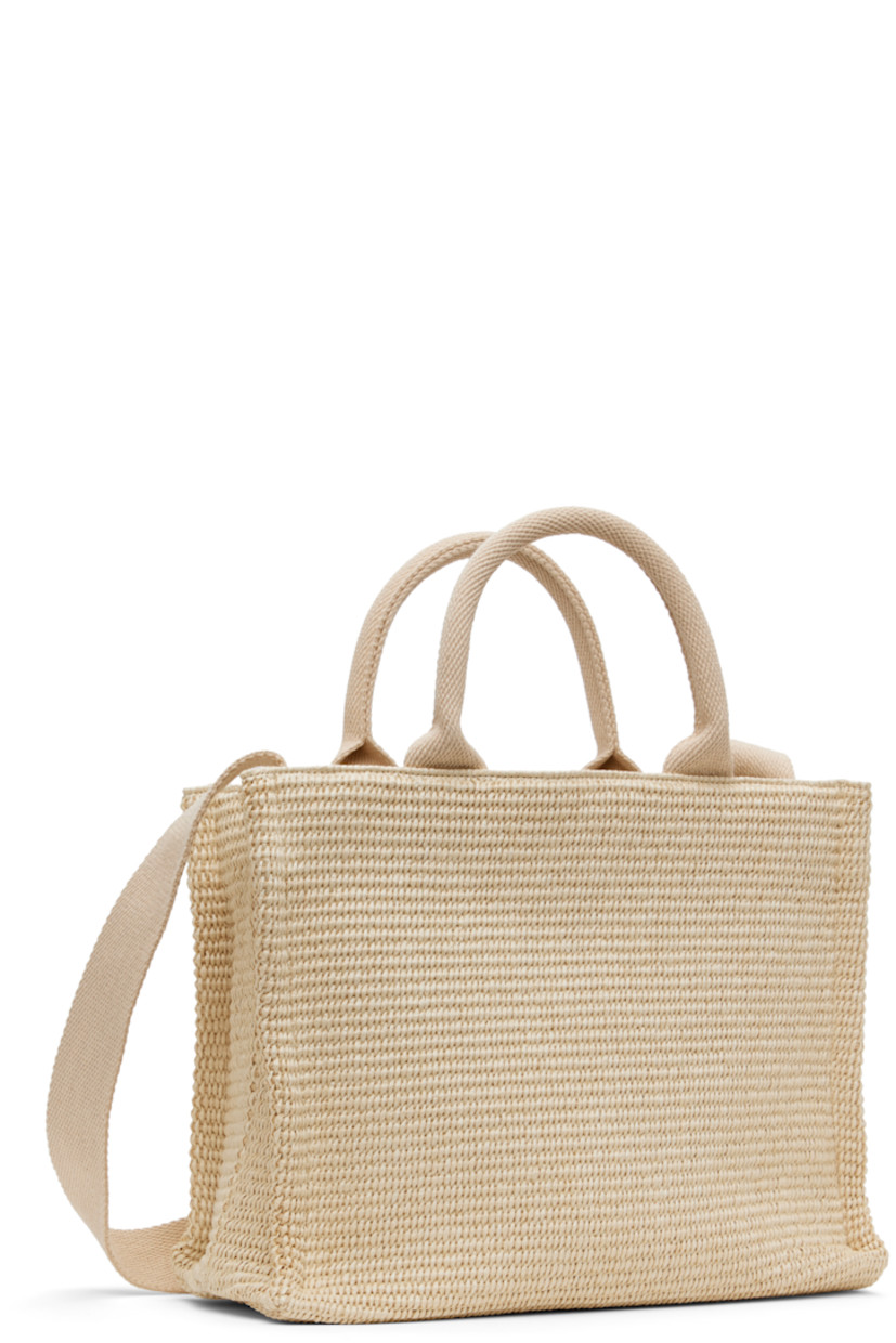 Woven faux-raffia tote in off-white.

· Fixed rolled carry handles
· Fixed crossbody strap
· Logo embroidered at face
· Post-stud tab fastening at throat
· Zip pocket at interior
· Twill lining
· H9" x W12.5" x D5"

Supplier color: Silk white