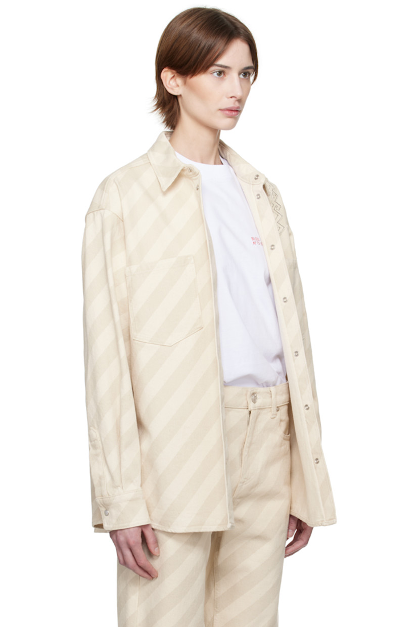 Non-stretch denim shirt. Stripes throughout. 

· Spread collar
· Press-stud closure
· Patch pockets
· Shirttail hem
· Logo appliqué at shoulder 
· Dropped shoulders
· Pleat and press-stud fastening at cuffs
· Twin pleats at yoke 

Supplier color: Bone