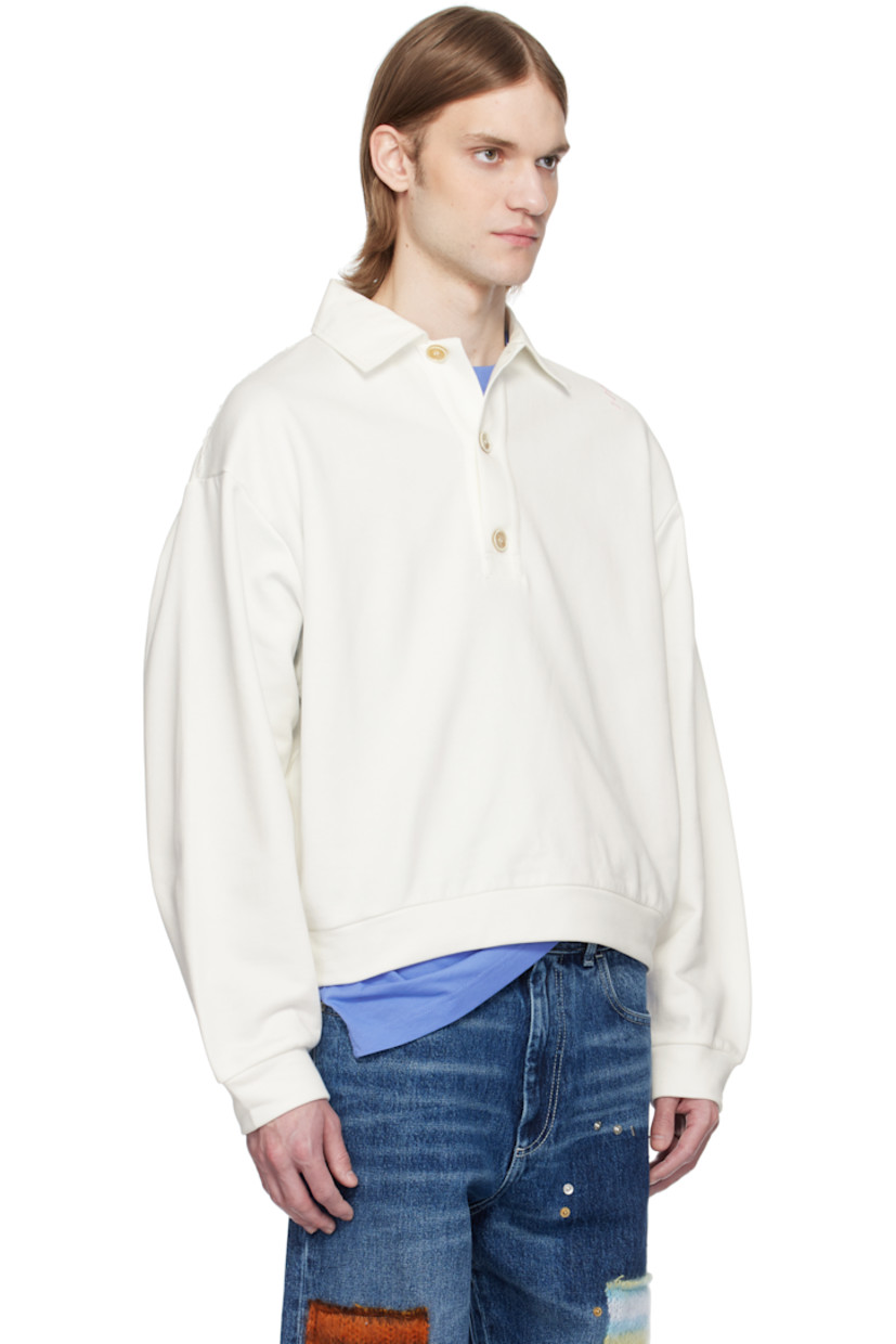 French terry polo.

· Spread collar
· Three-button placket
· Rib-knit hem and cuffs
· Frayed edge at shoulder seams
· Hand-stitched logo at shoulder
· Dropped shoulders
· Logo-engraved hardware

Supplier color: Natural white