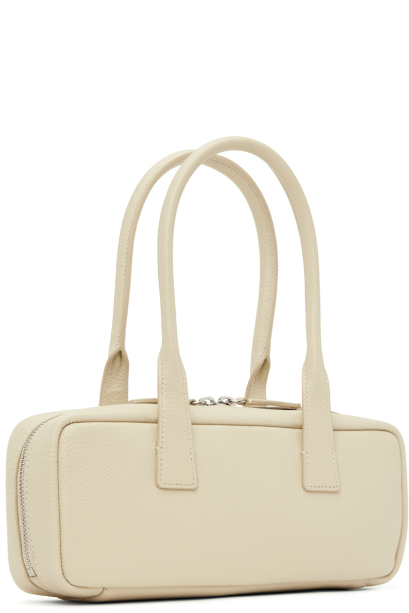 Pebble-grained leather shoulder bag in off-white. 

· Twin rolled shoulder straps
· Logo embossed at face
· Two-way zip closure
· Zip pocket at interior
· Full faille lining
· H4.5" x W11" x D3"

Supplier color: Cream