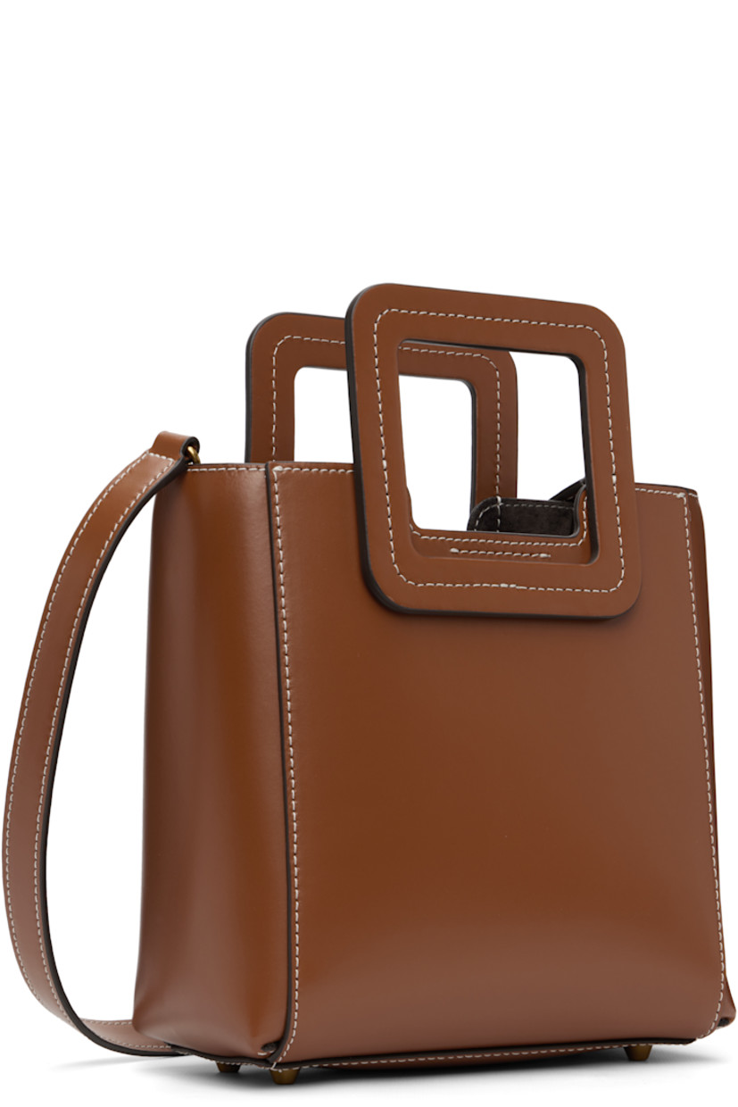 Buffed leather top handle bag.

· Fixed carry handles
· Adjustable and detachable crossbody strap
· Bumper studs and embossed logo at base
· Removable zip pouch at interior
· Suede lining
· Contrast stitching in white
· H8" x W8.25" x D4.5"

Supplier color: Saddle