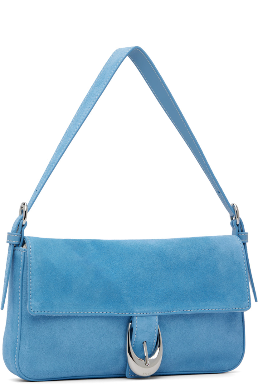 Suede shoulder bag.

· Adjustable shoulder strap
· Logo embossed at back face
· Pin-buckle hardware at magnetic press-stud flap
· Zip pocket at interior
· Logo-engraved silver-tone hardware
· H5" x W9.75" x D1.5"

Supplier color: Staud blue
