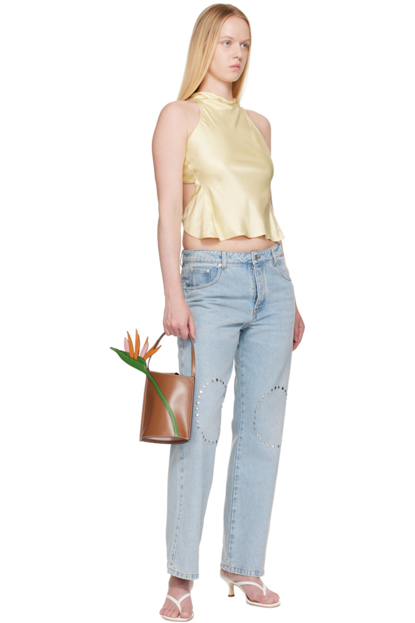 Polished leather top handle bag.

· Fixed carry handle
· Floral appliqué at face
· Logo embossed at back face
· Magnetic press-stud tab closure
· Suede interior
· Contrast stitching in white
· H7.5" x W6" x D3.75"

Supplier color: Tan