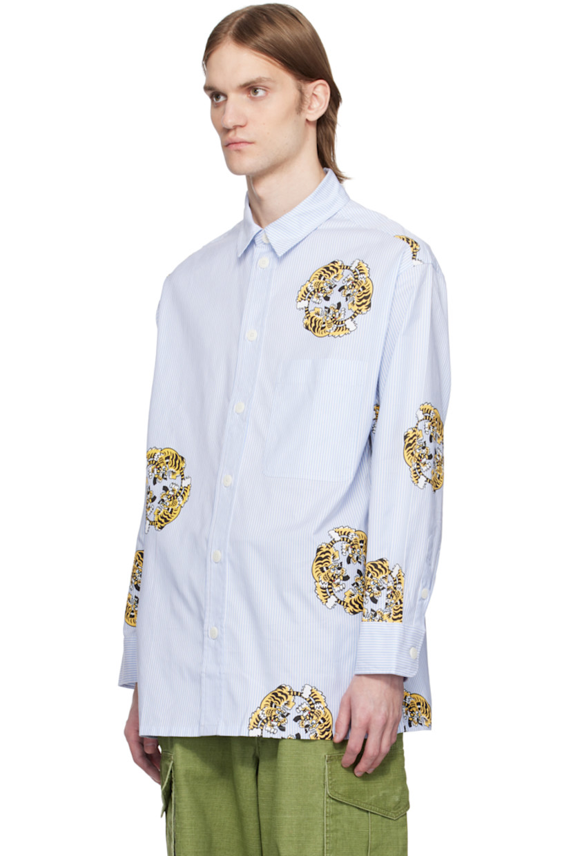 Oversized cotton poplin shirt. Jacquard stripes and printed graphics throughout.

· Spread collar
· Button closure
· Patch pocket at chest
· Vented side seams
· Dropped shoulders
· Pleats at buttoned barrel cuffs
· Logo-engraved hardware

Each item is unique. Please note finishing may vary.

Part of the KENZO VERDY Market collaboration.

Supplier color: Sky blue