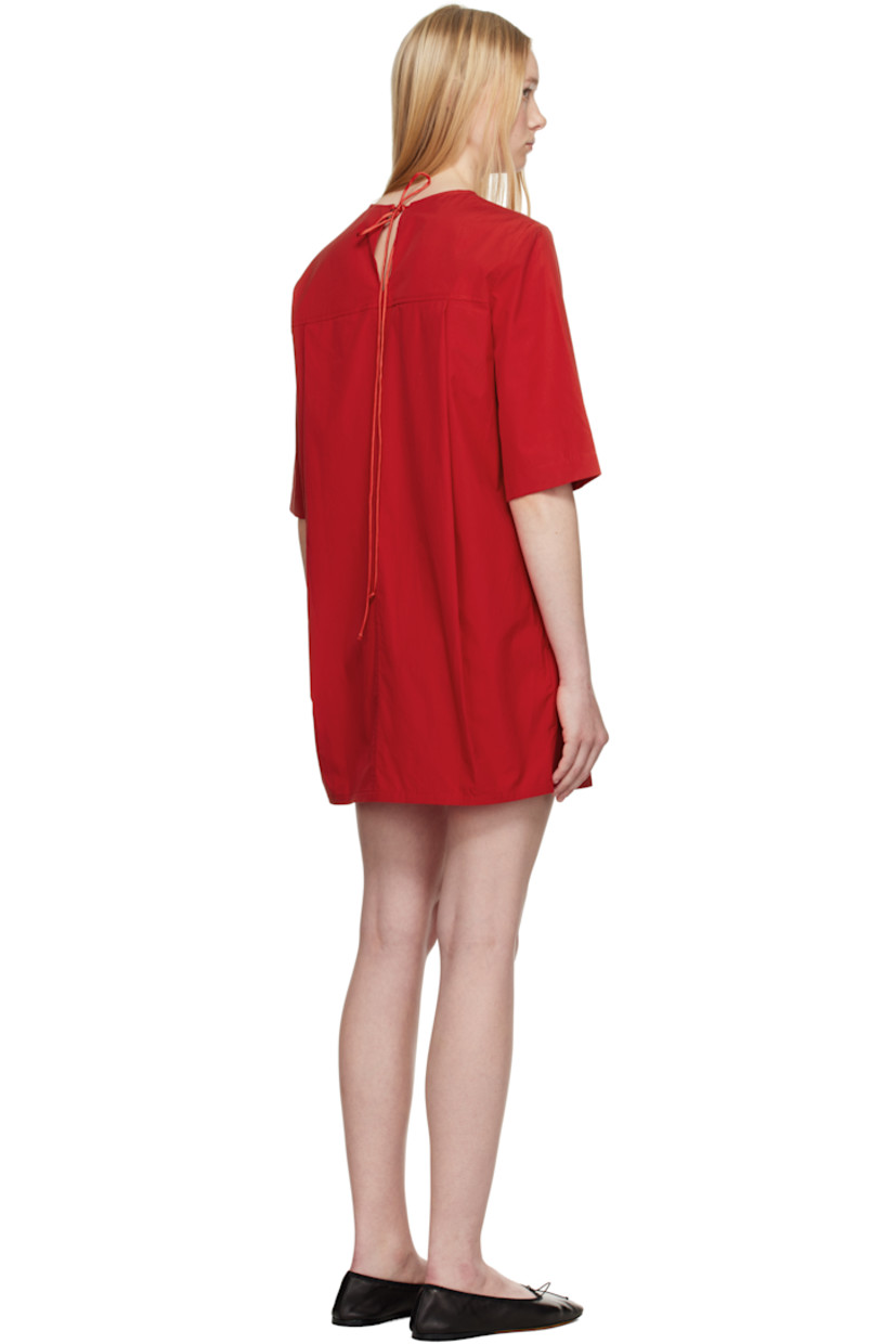 Organic cotton poplin minidress. 

· Round neck
· Seam pockets
· Dropped shoulders
· Self-tie keyhole with extended silk drawstring at back
· Twin pleats at back yoke
· Unlined

Supplier color: Red apple