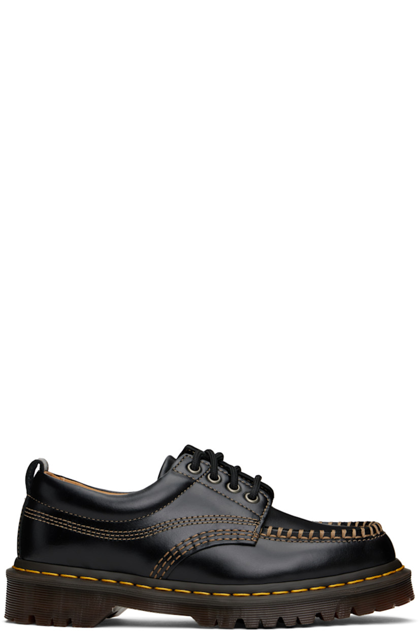 Buffed leather derbys in black.

· Blanket stitching at moc toe
· Lace-up closure
· Padded collar
· Pull-loop at heel collar
· Yellow topstitching at heat-sealed Goodyear welt
· Treaded Air Cushion rubber sole
· Contrast stitching in beige

Supplier color: Black analine
