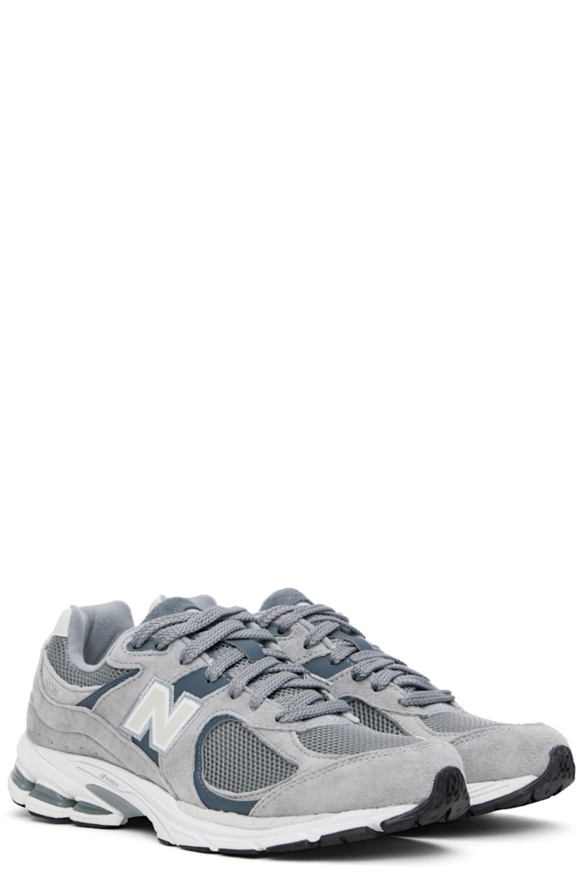 Low-top pigskin suede and mesh sneakers in gray.

· Reflective trim at toe
· Logo embroidered at vamp
· Lace-up closure
· Inset logo patch at padded tongue
· Padded collar
· Logo appliqué at sides
· Perforated detailing at heel counter
· Jersey lining
· ABZORB® foam rubber midsole
· Treaded N-ergy rubber sole
· Stability Web technology at sole

Supplier color: Steel/Lead/Orca