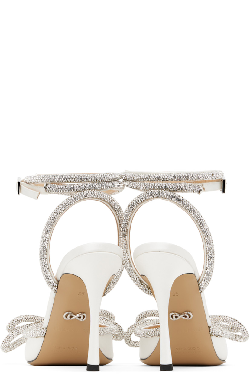 Silk satin heels in white.

· Crystal-cut detailing throughout
· Pointed toe
· Bow accent at vamp
· Wraparound pin-buckle ankle strap
· Logo stamp at padded leather footbed
· Buffed leather lining
· Covered stiletto heel with rubber injection
· Leather sole
· Heel: H4"

Supplier color: White