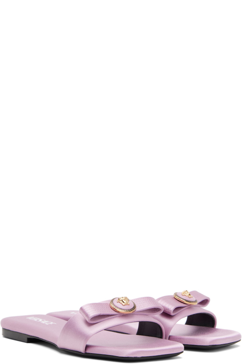 Silk-blend satin mules.

· Logo hardware and bow accent at vamp 
· Logo printed at padded footbed
· Stacked leather heel with rubber injection
· Leather sole 

Supplier color: Dusty lavender/Versace gold