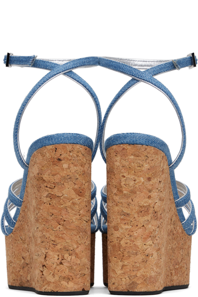Denim heeled sandals in blue.

· Open square toe
· Straps and crystal-cut graphic hardware at vamp
· Pin-buckle ankle strap
· Logo stamp at padded footbed
· Grained leather lining
· Cork wedge heel and platform midsole
· Treaded rubber sole
· Platform: H2"
· Heel: H4.75"

Supplier color: Blue