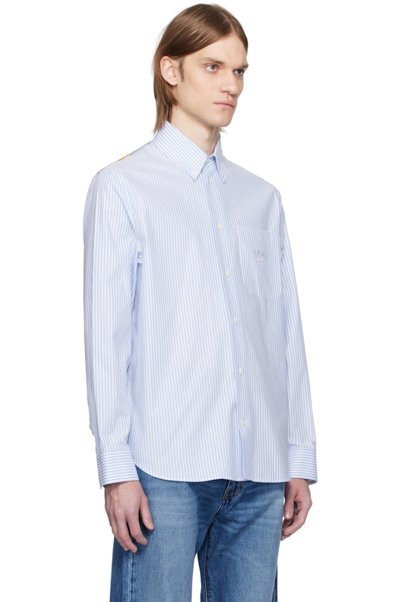 Cotton poplin shirt. Stripe pattern throughout.

· Button-down spread collar
· Button closure
· Logo and text embroidered at patch pocket
· Shirttail hem
· Buttoned barrel cuffs
· Logo graphic printed at silk poplin yoke

Supplier color: Pastel blue