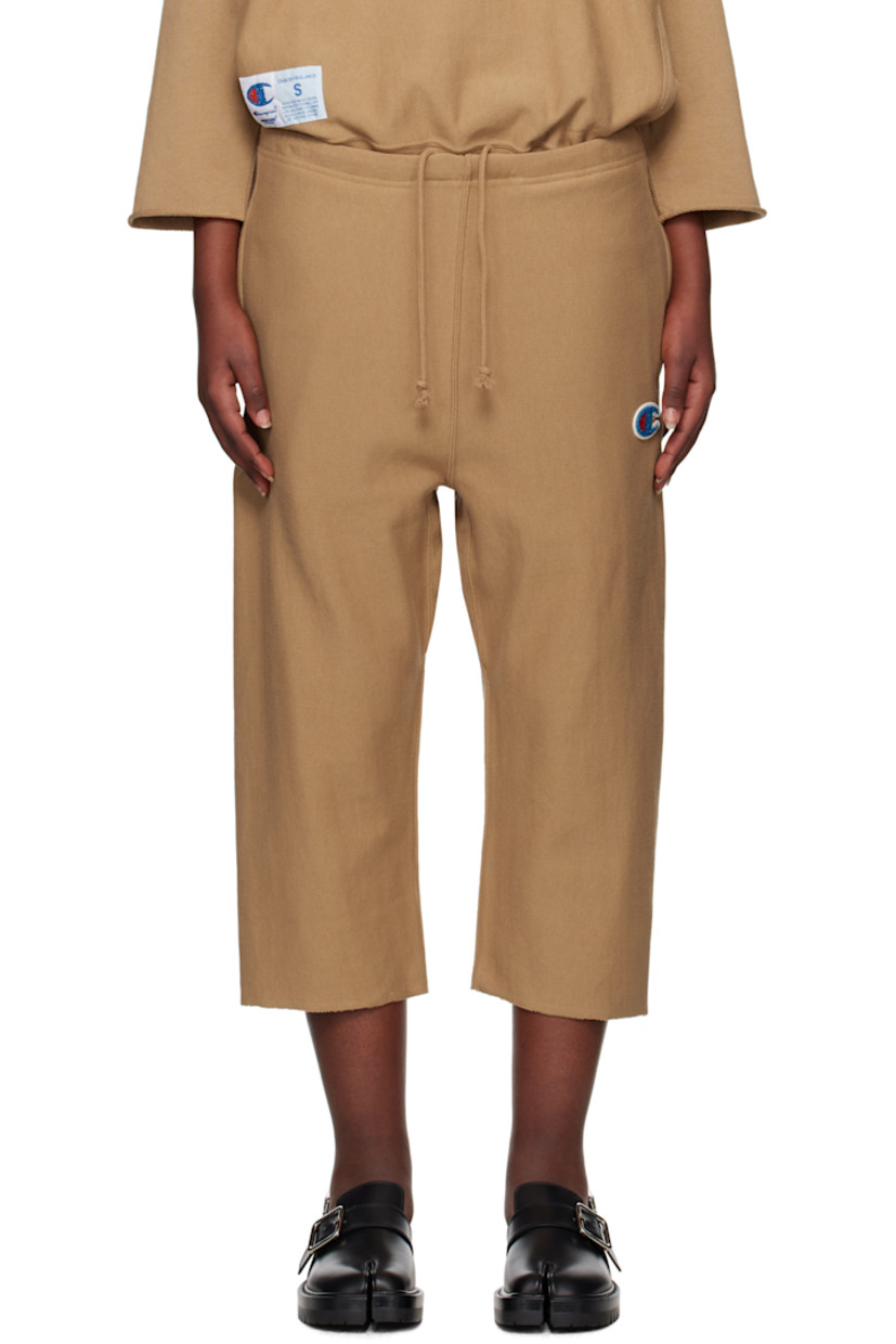 French terry sweatpants. 

· Concealed drawstring at elasticized waistband
· Three-pocket styling
· Beaded logo appliqué at leg
· Cropped legs
· Raw edge at cuffs
· Logo patch at back pocket

Part of the UNDERCOVER x Champion collaboration.

Supplier color: Beige