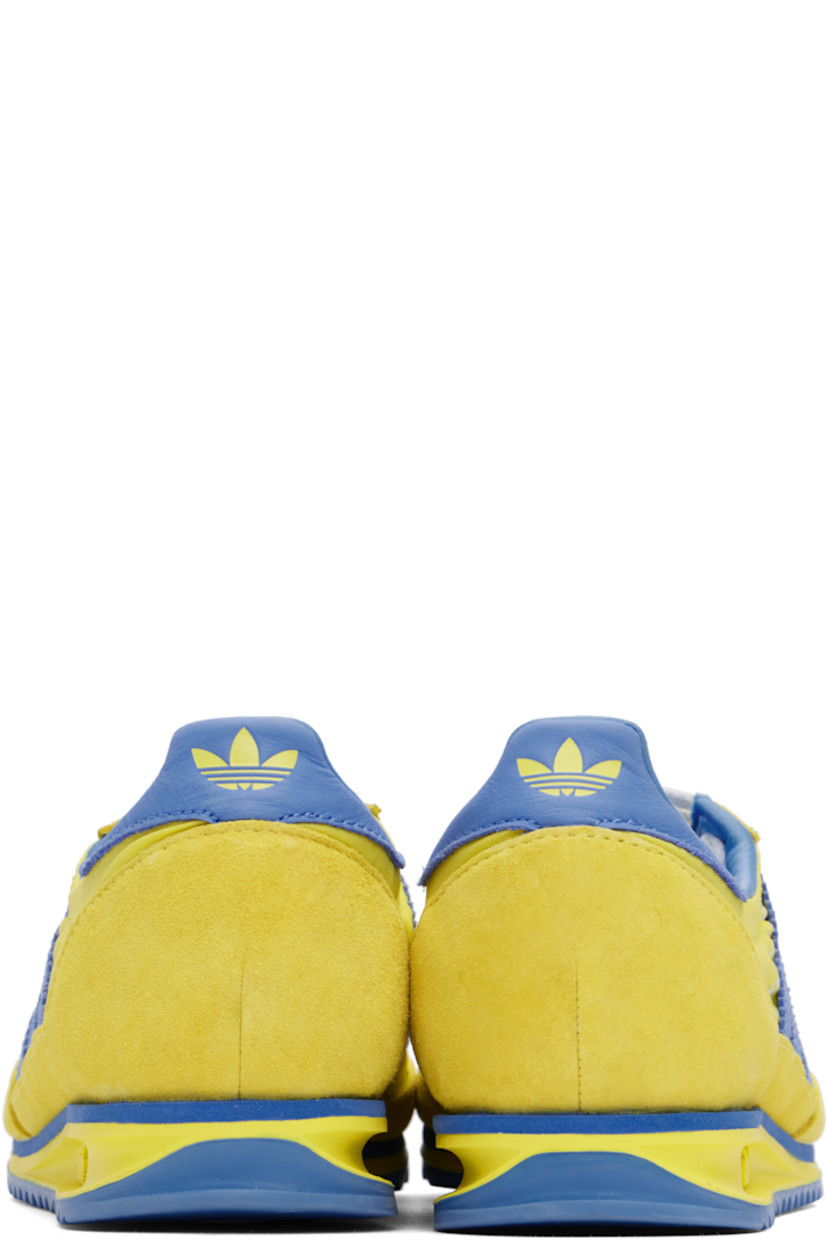 Low-top canvas and suede sneakers in yellow and blue.

· Lace-up closure
· Logo patch at padded tongue
· Padded collar
· Logo printed at outer side
· Signature serrated stripes at sides
· Logo printed at heel tab
· Logo embossed at midsole
· Treaded rubber sole

Part of the Sporty & Rich x adidas Originals collaboration.

Supplier color: Light yellow/Real blue
