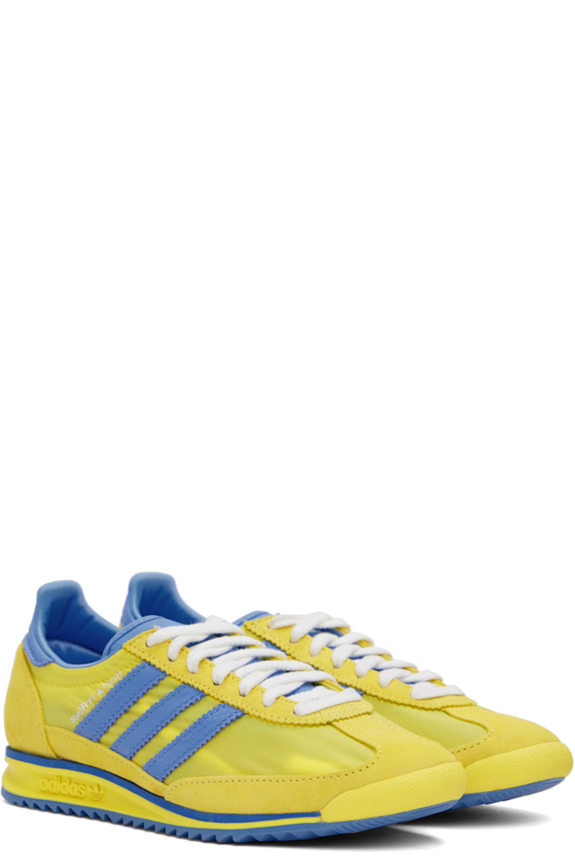 Low-top canvas and suede sneakers in yellow and blue.

· Lace-up closure
· Logo patch at padded tongue
· Padded collar
· Logo printed at outer side
· Signature serrated stripes at sides
· Logo printed at heel tab
· Logo embossed at midsole
· Treaded rubber sole

Part of the Sporty & Rich x adidas Originals collaboration.

Supplier color: Light yellow/Real blue