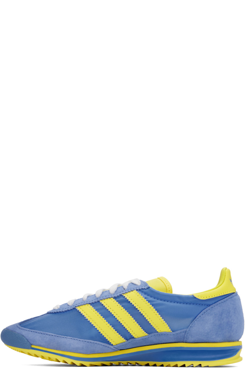 Low-top canvas and suede sneakers in yellow and blue.

· Lace-up closure
· Logo patch at padded tongue
· Padded collar
· Logo printed at outer side
· Signature serrated stripes at sides
· Logo printed at heel tab
· Logo embossed at midsole
· Treaded rubber sole

Part of the Sporty & Rich x adidas Originals collaboration.

Supplier color: Real blue/Light yellow