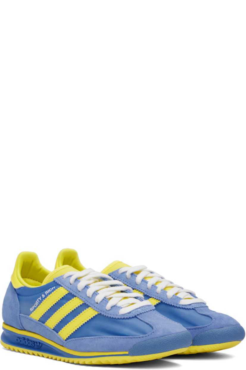 Low-top canvas and suede sneakers in yellow and blue.

· Lace-up closure
· Logo patch at padded tongue
· Padded collar
· Logo printed at outer side
· Signature serrated stripes at sides
· Logo printed at heel tab
· Logo embossed at midsole
· Treaded rubber sole

Part of the Sporty & Rich x adidas Originals collaboration.

Supplier color: Real blue/Light yellow