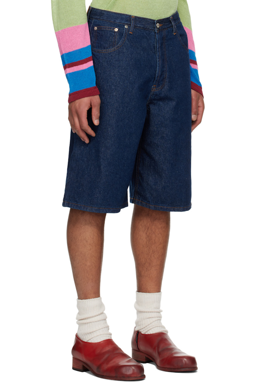 Non-stretch denim shorts. 

· Belt loops
· Five-pocket styling 
· Button-fly 
· Logo patch at back waistband
· Cutout with frayed edges at back pocket
· Graphic embroidered at back pockets
· Logo-engraved silver-tone hardware
· Contrast stitching in tan

Supplier color: Indigo wash