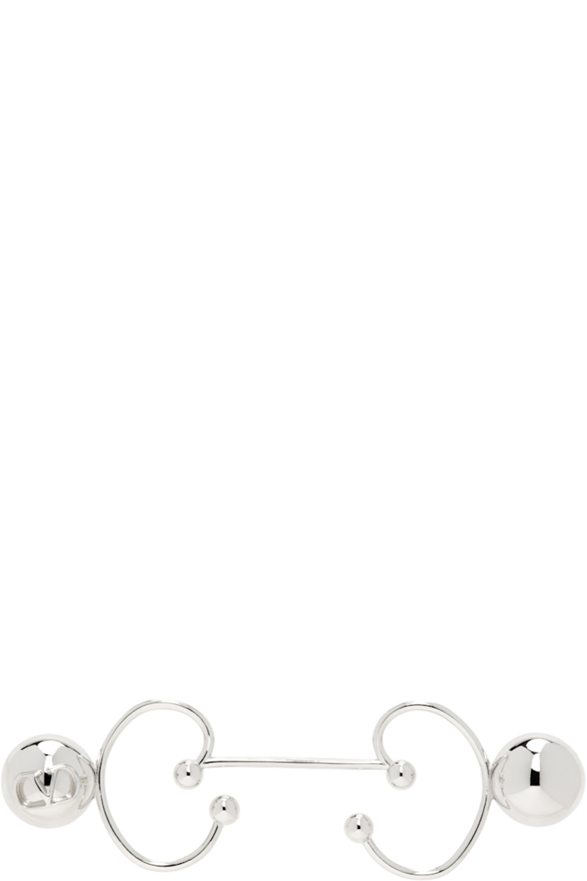 Single ear cuff in silver tone. 

· Logo hardware at side
· H0.5" x W2"

Supplier color: Palladium
