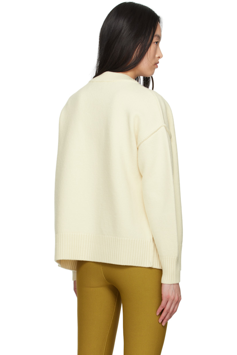 Felted knit virgin wool cardigan. Inverted seams throughout.

· Rib-knit Y-neck, hem, and cuffs
· Button closure
· Intarsia logo at chest
· Dropped shoulders

Supplier color: Off white/Red