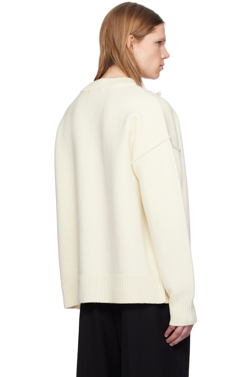 Felted knit virgin wool cardigan. Inverted seams throughout.

· Rib-knit Y-neck, hem, and cuffs
· Button closure
· Intarsia logo at chest
· Dropped shoulders

Supplier color: Off white/Red
