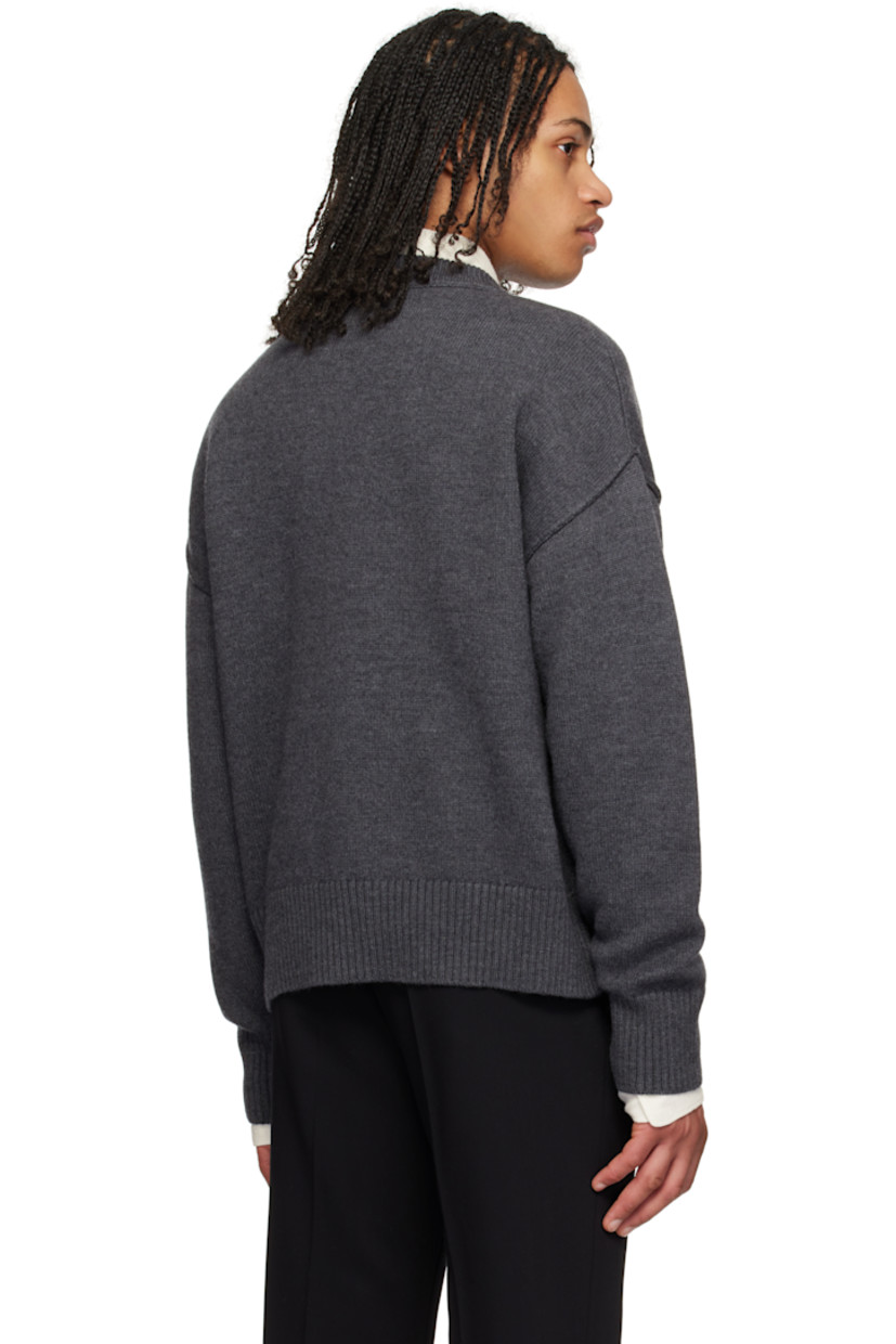 Felted knit virgin wool sweater. Raised seams throughout.

· Rib-knit crewneck, hem, and cuffs
· Intarsia logo at chest
· Dropped shoulders

Supplier color: Heather grey/Red