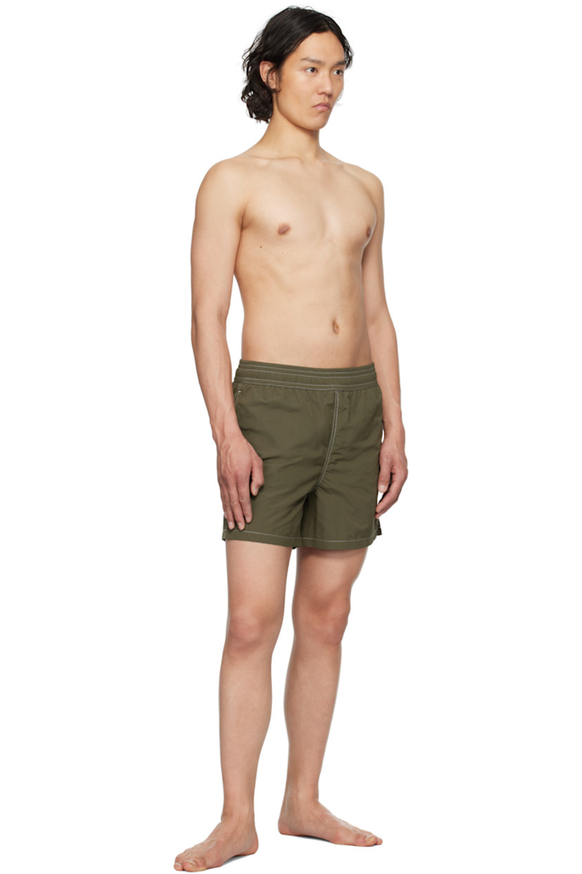 Nylon technical canvas swim shorts.

· Concealed drawstring at elasticized waistband
· Three-pocket styling
· Logo embroidered at leg
· Vent at outseams
· Brief-style mesh lining
· Contrast stitching in white

Supplier color: Loden