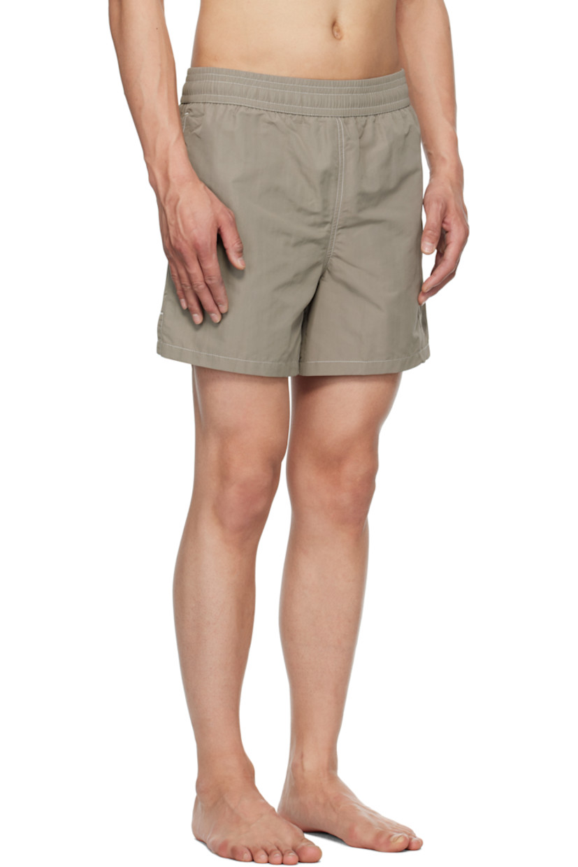 Nylon technical canvas swim shorts.

· Concealed drawstring at elasticized waistband
· Three-pocket styling
· Logo embroidered at leg
· Vent at outseams
· Brief-style mesh lining
· Contrast stitching in white

Supplier color: Ash