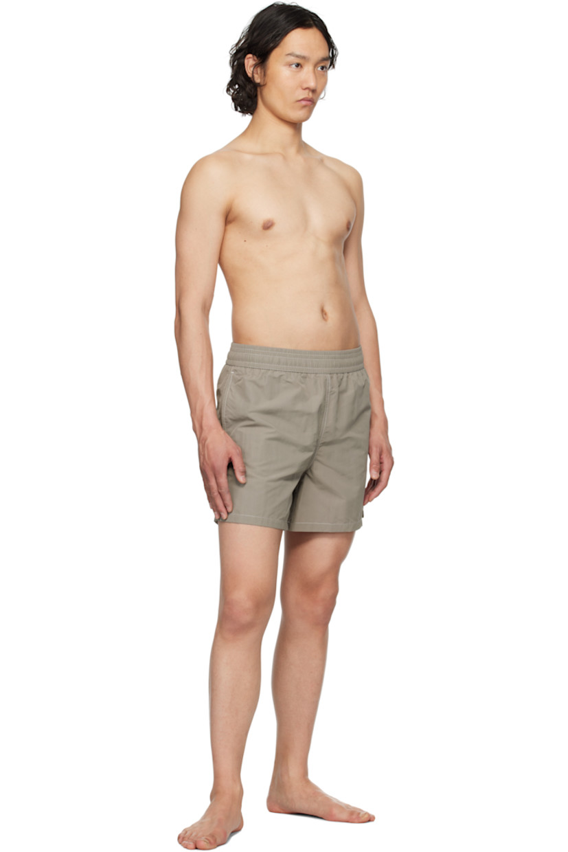Nylon technical canvas swim shorts.

· Concealed drawstring at elasticized waistband
· Three-pocket styling
· Logo embroidered at leg
· Vent at outseams
· Brief-style mesh lining
· Contrast stitching in white

Supplier color: Ash