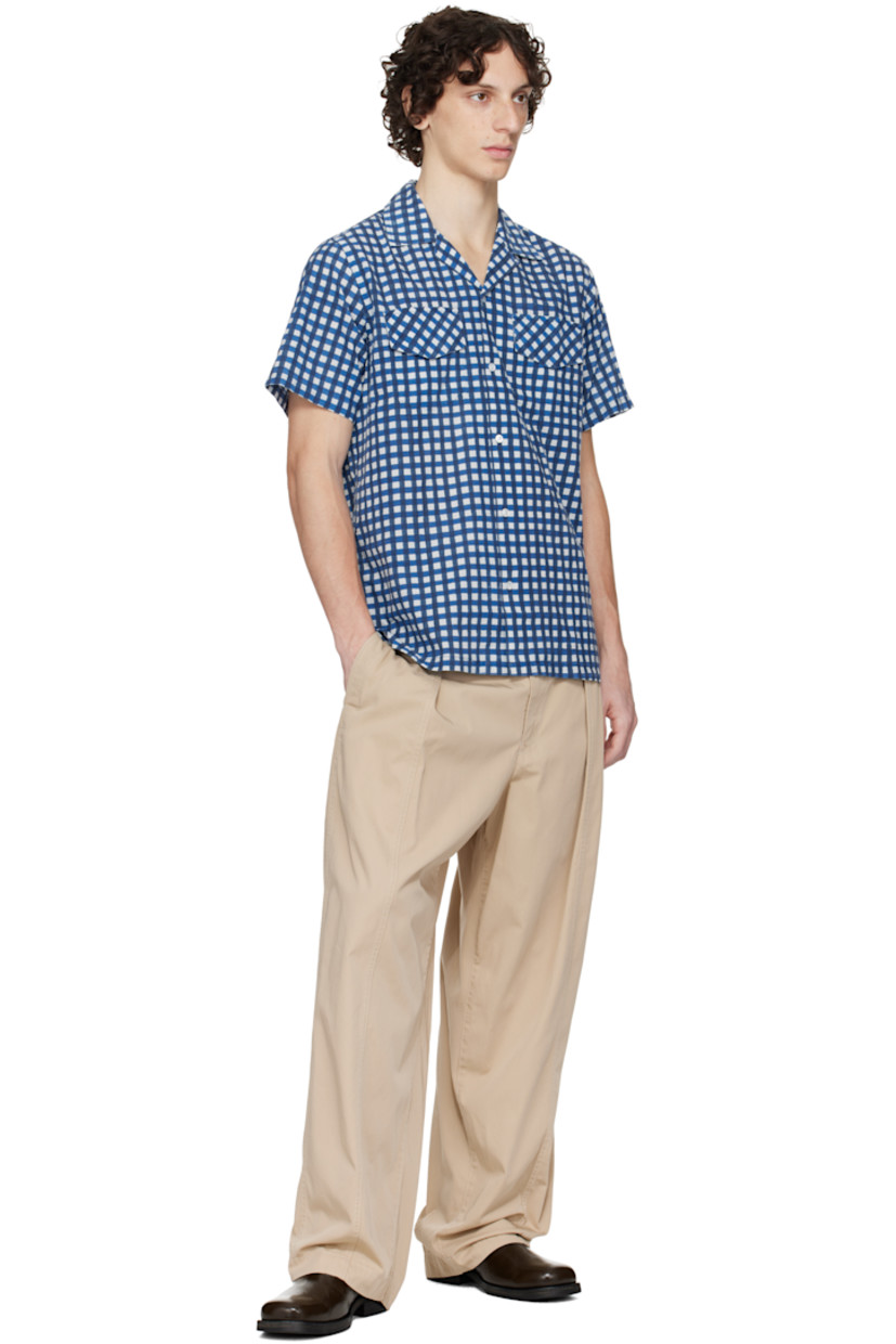 Plain-woven cotton shirt. 

· Gingham pattern printed throughout 
· Button tab at open spread collar 
· Button closure
· Flap pockets
· Vented side seams
· Mother-of-pearl hardware

Supplier color: Navy
