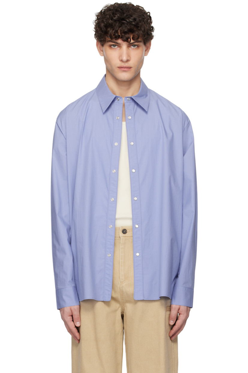 Cotton poplin shirt. 

· Spread collar
· Press-stud closure
· Shirttail hem
· Adjustable single-press-stud barrel cuffs
· Logo hardware at back collar
· Box pleat at back yoke

Supplier color: Blue