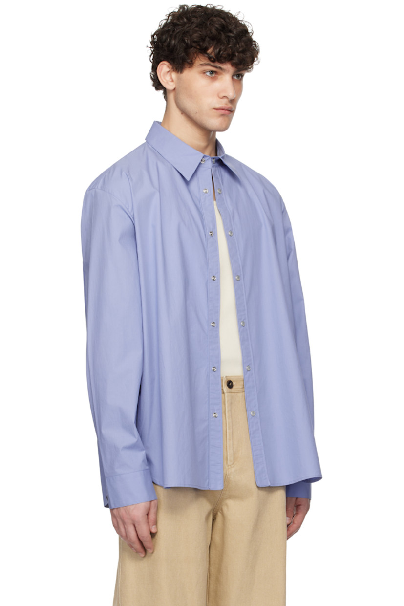 Cotton poplin shirt. 

· Spread collar
· Press-stud closure
· Shirttail hem
· Adjustable single-press-stud barrel cuffs
· Logo hardware at back collar
· Box pleat at back yoke

Supplier color: Blue