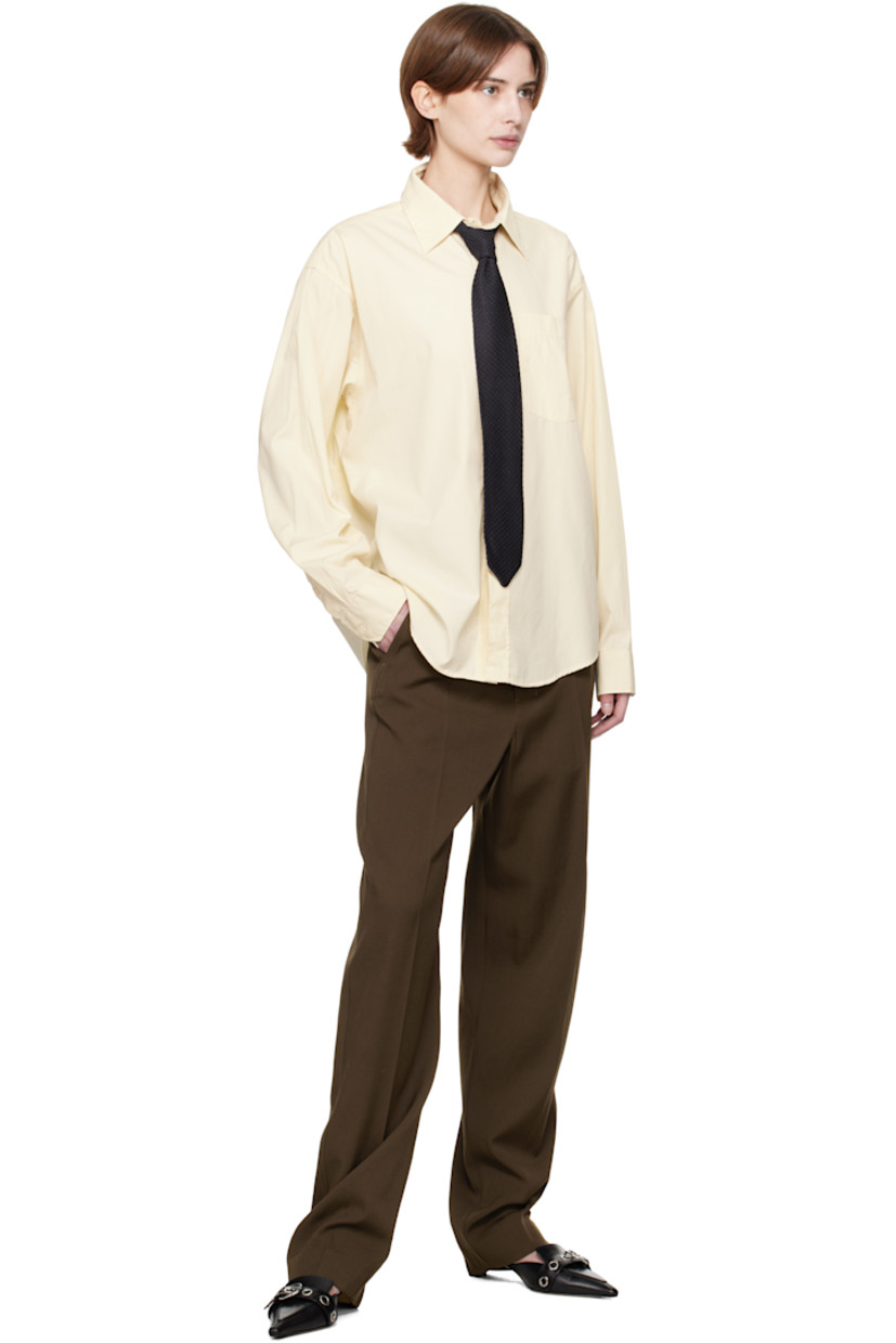 Garment-washed deadstock cotton poplin shirt. 

· Spread collar
· Button closure
· Patch pocket
· Shirttail hem
· Dropped shoulders
· Single-button barrel cuffs
· Box pleat at yoke

Supplier color: Faded yellow