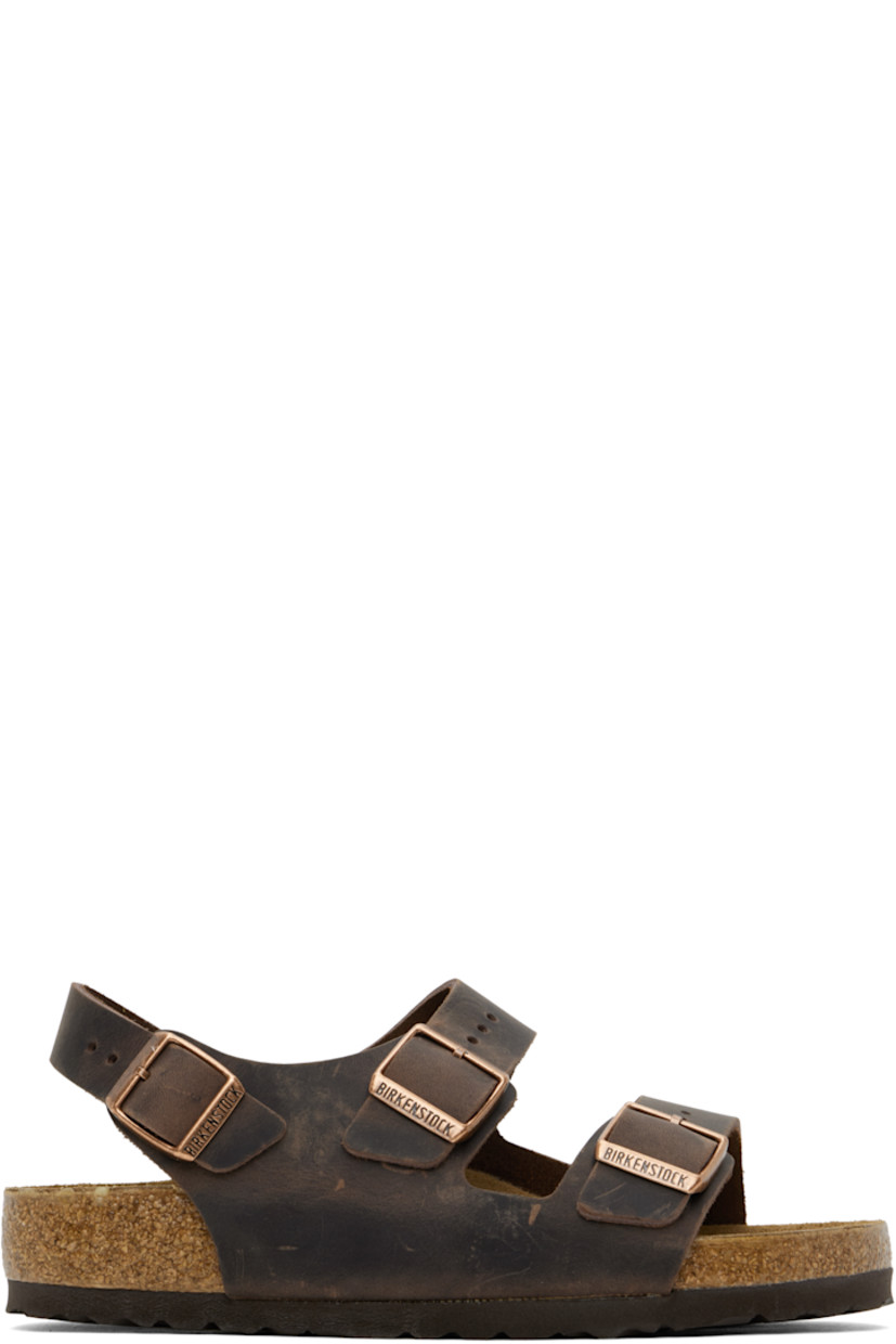 Handcrafted oiled nubuck flat sandals in brown.

· Fading throughout
· Open toe
· Adjustable pin-buckle straps at vamp
· Adjustable pin-buckle ankle strap
· Logo embossed at inner side
· Logo printed at molded suede footbed
· Cork midsole
· Treaded rubber sole
· Logo-engraved copper-tone hardware

Supplier color: Habana