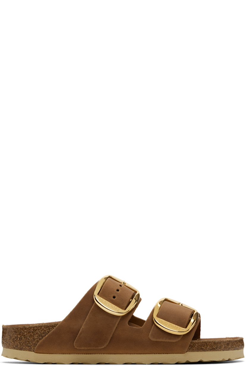 Oiled leather flat sandals in brown.

· Open toe
· Adjustable pin-buckle straps at vamp
· Logo embossed at inner side
· Logo printed at molded leather footbed
· Cork midsole
· Treaded rubber sole
· Logo-engraved gold-tone hardware

Supplier color: Cognac