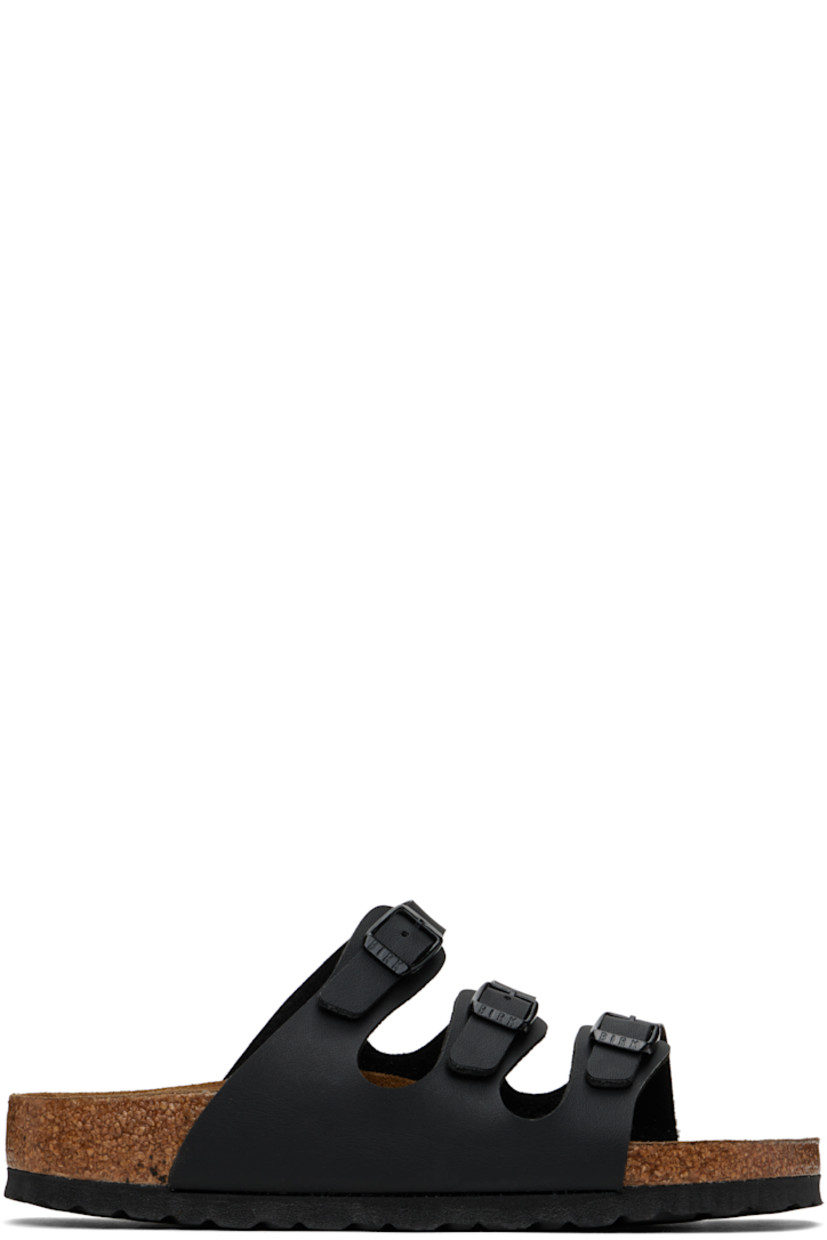 Buffed Birko-Flor® faux-leather slip-on flat sandals in black. 

· Open toe
· Adjustable pin-buckle straps at vamp
· Logo embossed at inner side
· Cushioned molded suede footbed
· Cork-latex midsole
· Treaded foam rubber sole
· Logo-engraved black hardware

Supplier color: Black