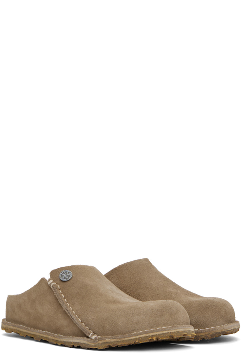 Suede slip-on loafers in beige.

· Logo hardware at vamp
· Pinched seam at outer side
· Logo embossed at inner side
· Logo printed at molded suede footbed
· Cork-latex midsole
· Treaded rubber sole
· Contrast stitching in white

Supplier color: Gray taupe