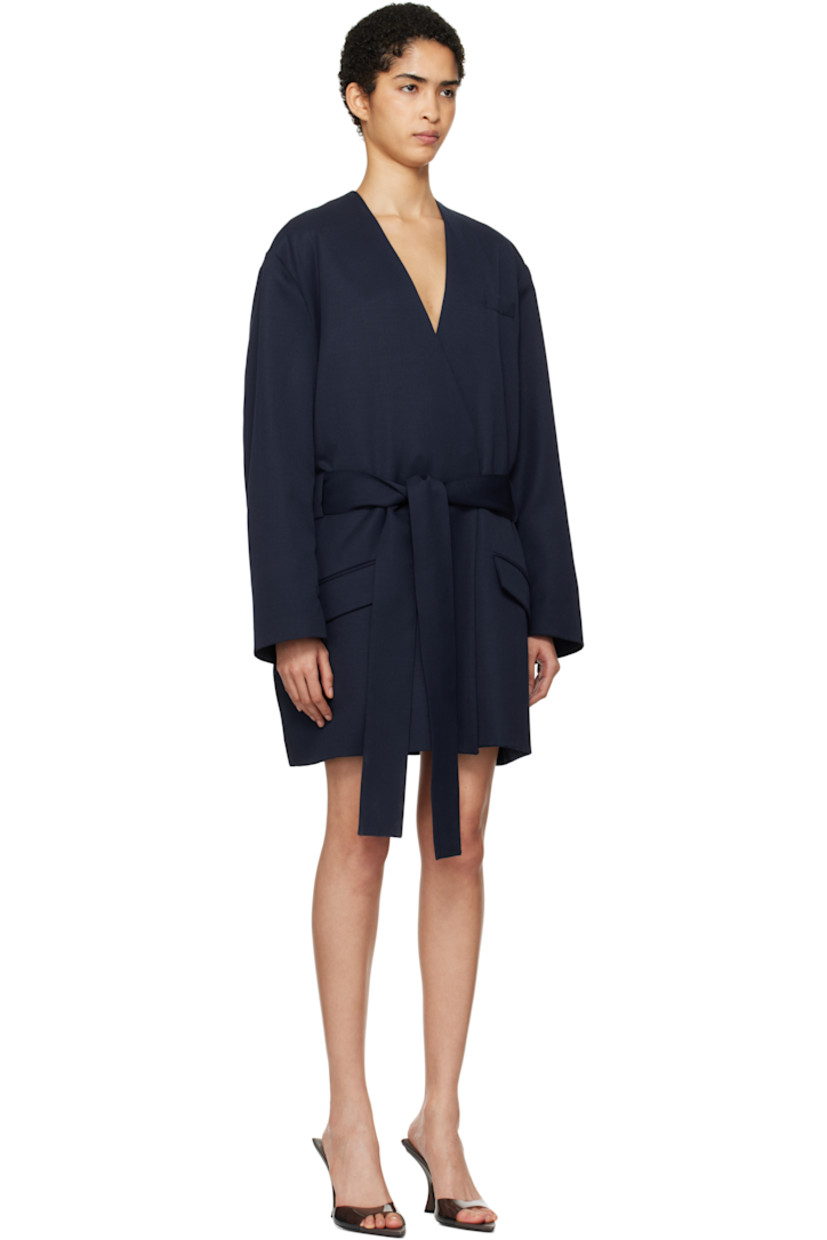 Virgin wool twill blazer. 

· Wrap construction
· Y-neck
· Welt pocket and flap pockets
· Concealed button closure
· Belt loops and detachable self-tie belt 
· Logo hardware at flap pocket 
· Twin vents at back hem 
· Partially lined

Supplier color: Navy blue