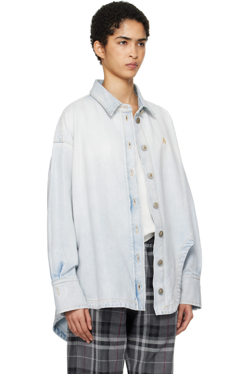 Coated non-stretch denim shirt. Fading throughout. 

· Spread collar
· Button closure
· Logo embroidered at chest
· Asymmetric shirttail hem 
· Dropped shoulders
· Pleats at two-button barrel cuffs
· Box pleat at back yoke
· Logo-engraved antiqued silver-tone hardware
· Contrast stitching in tan

Supplier color: Sky blue