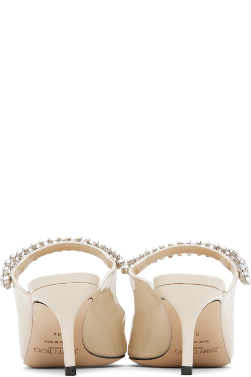 Patent leather mules.

· Pointed toe
· Crystal-cut accents at fixed strap
· Logo patch at grained leather footbed
· Covered stiletto heel
· Nubuck sole
· Heel: H2.5"

Supplier color: Linen
