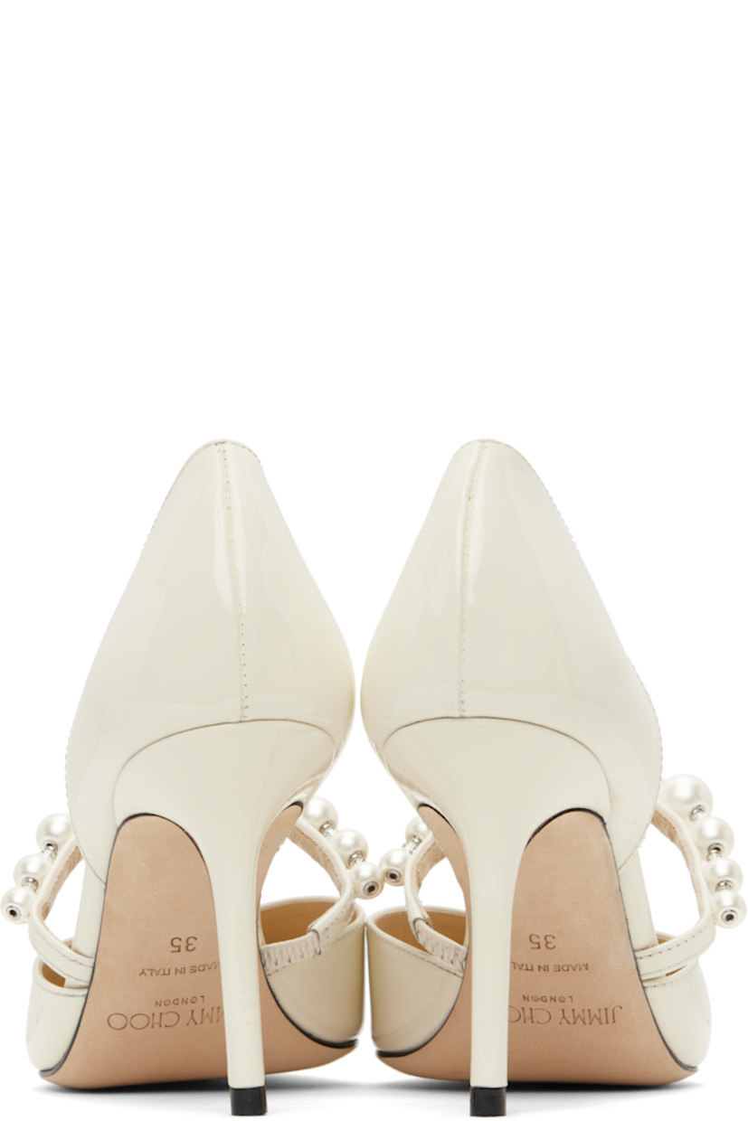 Patent leather heels in off-white.

· Pointed toe
· Faux-pearl and beaded accents at vamp
· Partially elasticized strap 
· Logo patch at padded leather footbed
· Covered heel with rubber injection
· Nubuck sole
· Heel: H3.5"

Supplier color: Latte
