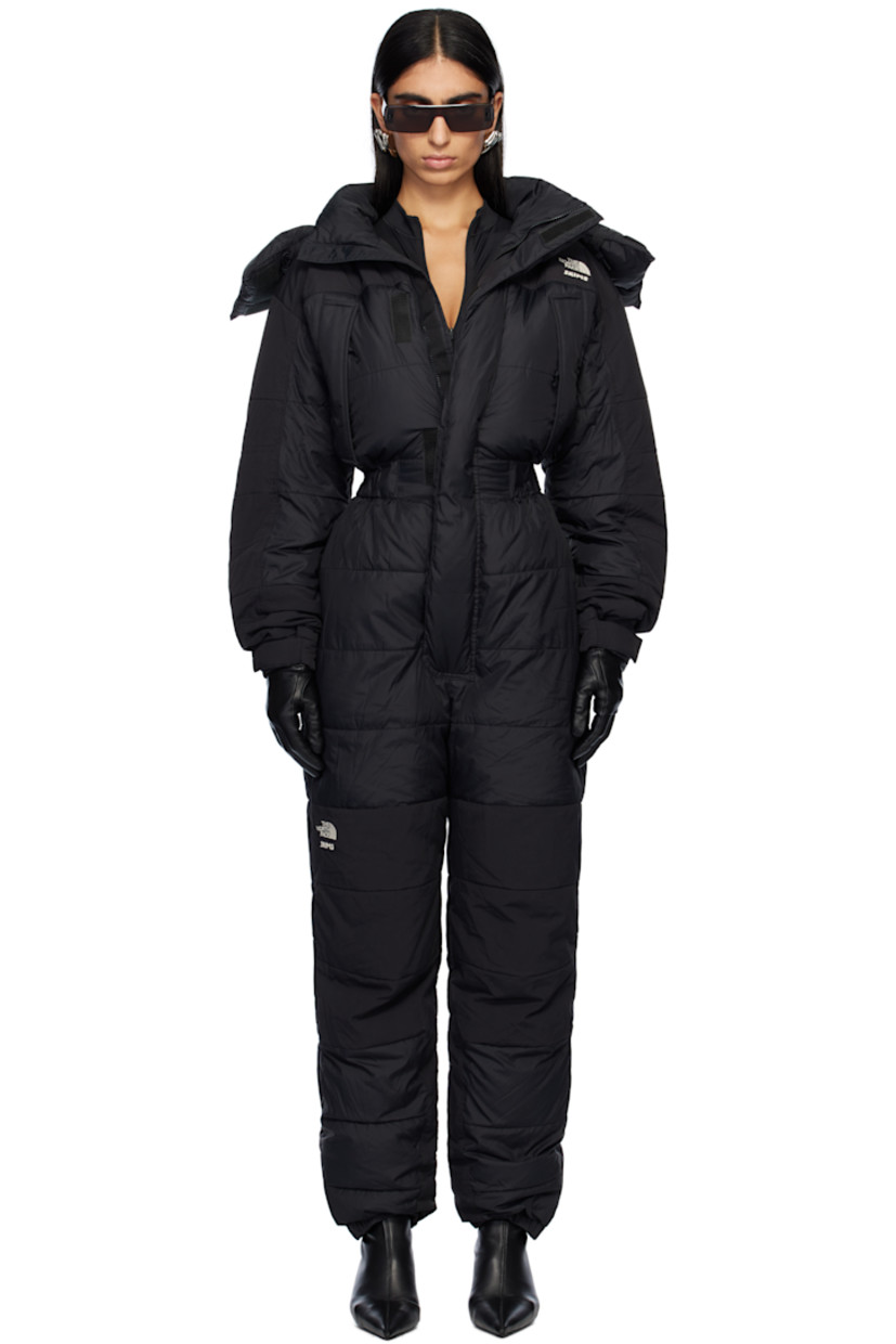 Down-filled and quilted nylon taffeta snow suit.

· Bungee-style drawstring at detachable hood 
· Funnel neck
· Concealed zip closure and velcro placket
· Logo embroidered at chest, leg, and back
· Zip pockets
· Elasticized waist
· Press-stud tabs at elasticized hem 
· Concealed zip vent at outseams
· Text embroidered at sleeve
· Velcro tab at cuffs
· Fully lined

Part of The North Face x SKIMS collaboration.

Available exclusively at SSENSE.

Supplier color: Onyx

Fill: 85% down, 15% waterfowl feathers.
